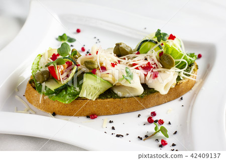 Bruschetta with pesto sauce, fish, fresh vegetable Bruschetta with pesto sauce, fish, fresh vegetable 42409137