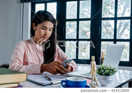 Business woman working and using smart phone Business woman working and using smart phone 42411009