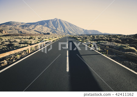 Straight asphalt road with peak of Pico del Teide Straight asphalt road with peak of Pico del Teide 42411162