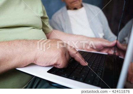 Retiree couple surfing internet using laptop 42411876