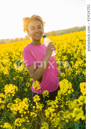 African American Girl Drinking Water at Sunset 42414701