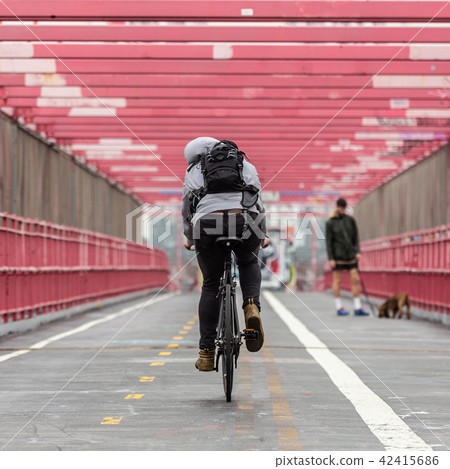 Man riding his bike in the cycling lane on Williamsburg Bridge, Brooklyn, New York City. Man riding his bike in the cycling lane on Williamsburg Bridge, Brooklyn, New York City. 42415686