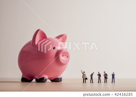 Business people looking at giant Piggy Bank 42416285