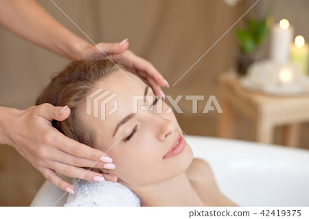Woman face with perfect skin doing facial massage in a bathtub 42419375