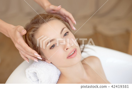 Woman face with perfect skin doing facial massage in a bathtub 42419381