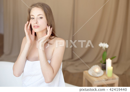 Caucasian smiling woman after spa covered with white towel Caucasian smiling woman after spa covered with white towel 42419440