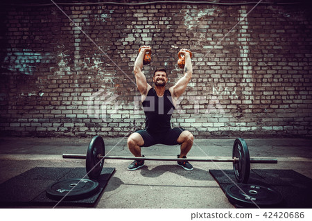 Athletic man working out with a kettlebell. Strength and motivation Athletic man working out with a kettlebell. Strength and motivation 42420686