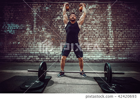 Athletic man working out with a kettlebell. Strength and motivation Athletic man working out with a kettlebell. Strength and motivation 42420693