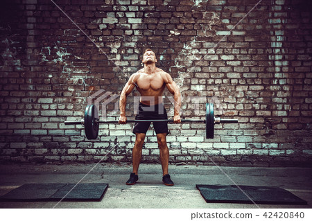 Muscular fitness man doing deadlift a barbell over his head in outdoor, street gym. Functional Muscular fitness man doing deadlift a barbell over his head in outdoor, street gym. Functional 42420840