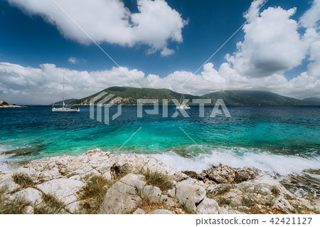 Crystal clear transparent blue turquoise teal Mediterranean sea water in Fiskardo town. White yacht 42421127
