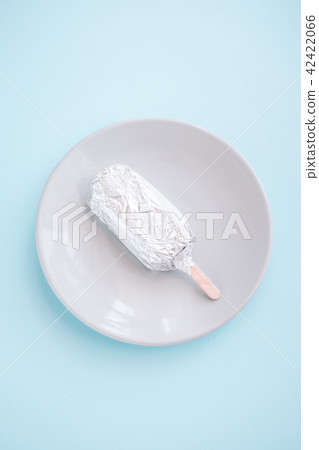 Wrapped ice-cream flat lay on pastel blue 42422066