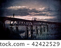 Man and dog walk across abandoned railway bridge 42422529