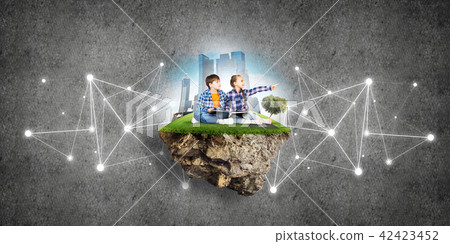 Two kids of school age with book exploring this great world 42423452