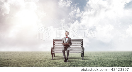 Young businessman or student studying the science in summer park Young businessman or student studying the science in summer park 42423597