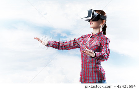 Girl in checked shirt wearing VR glasses experiencing another reality Girl in checked shirt wearing VR glasses experiencing another reality 42423694