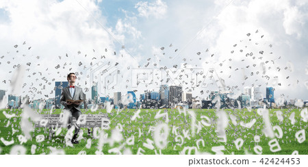 Young businessman or student studying the science and symbols fly around Young businessman or student studying the science and symbols fly around 42424453