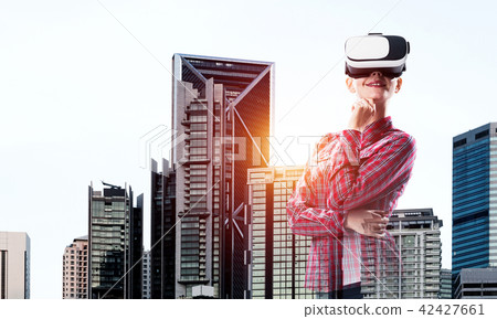Girl in checked shirt wearing VR glasses experiencing another reality Girl in checked shirt wearing VR glasses experiencing another reality 42427661