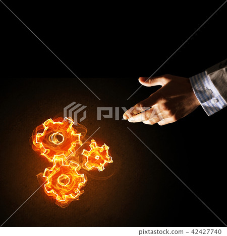 Concept of teamworking or organization presented by fire glowing cogwheels 42427740