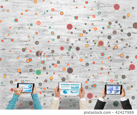 Top view of businesspeople sitting at table and using gadgets Top view of businesspeople sitting at table and using gadgets 42427989