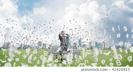 Young man on bench in summer park cant hear the sound Young man on bench in summer park cant hear the sound 42428923