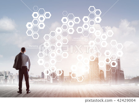 Pensive businessman looking at user interface against modern city background Pensive businessman looking at user interface against modern city background 42429004