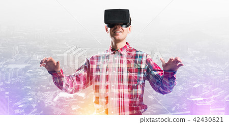 Guy wearing checked shirt and virtual mask stretching hands and trying to concentrate Guy wearing checked shirt and virtual mask stretching hands and trying to concentrate 42430821