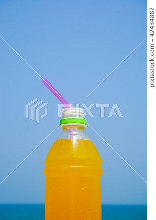 Orange juice drinking on the beach 42434882