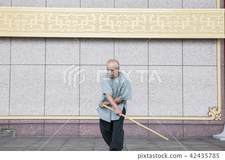Martial artist practicing Taiji stick 42435785