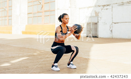 Female athlete doing squat exercises  42437243