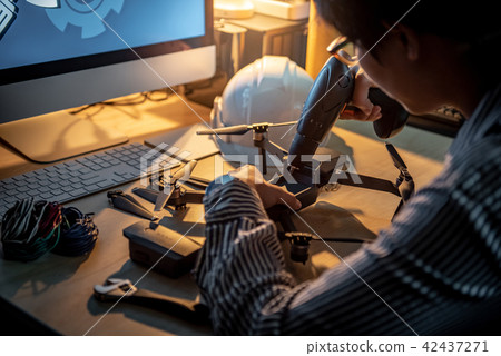 Technician using screwdriver for repairing drone 42437271