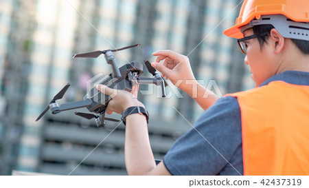 Asian engineer holding drone at construction site Asian engineer holding drone at construction site 42437319