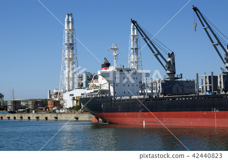 Cargo ship handling cargo and chimney of power plant Cargo ship handling cargo and chimney of power plant 42440823