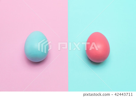 Two easter eggs stay static on table. 42443711
