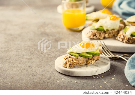 Sandwich with avocado and fried eggs 42444024