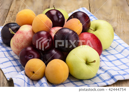 Fruit on a kitchen towel, apples, plums, apricots Fruit on a kitchen towel, apples, plums, apricots 42444754