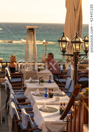 Mature couple sitting on restaurant on sea coast. Mature couple sitting on restaurant on sea coast. 42445180