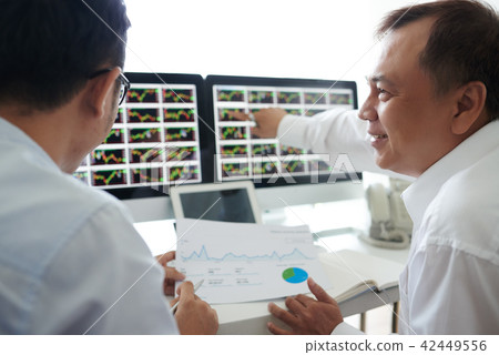 Brokers analyzing data on screen Brokers analyzing data on screen 42449556