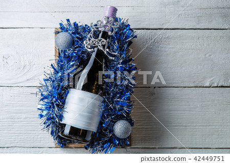 Photo of bottle of wine with blank card in box with tinsel, 42449751