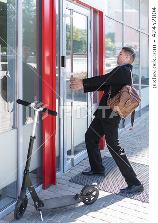 Businessman is pulling the door 42452004