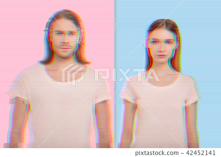 Confident young couple wearing similar clothes and standing against the colorful background Confident young couple wearing similar clothes and standing against the colorful background 42452141