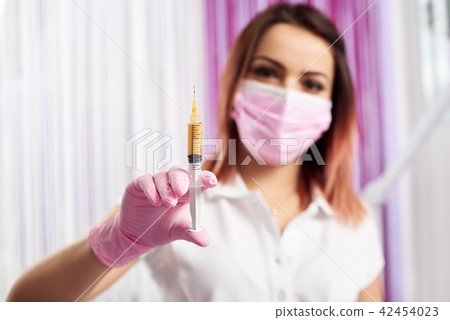 Close-up of cosmetologist prepares syringe for botox in beauty salon 42454023