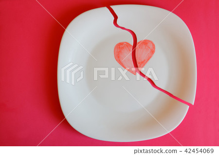 Broken plate with a painted heart on a red  42454069