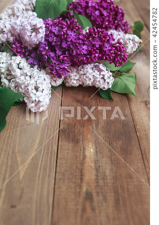 Bouquet of purple lilacs flowers on a brown wooden background Bouquet of purple lilacs flowers on a brown wooden background 42454782