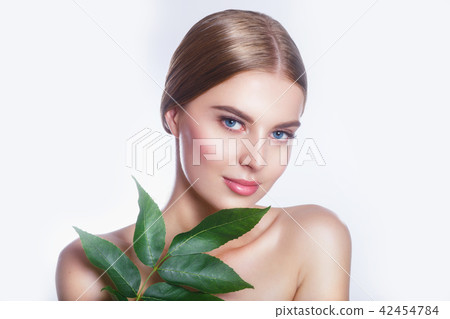 Beautiful woman face portrait with green leaf concept for skin care or organic cosmetics. Studio Beautiful woman face portrait with green leaf concept for skin care or organic cosmetics. Studio 42454784