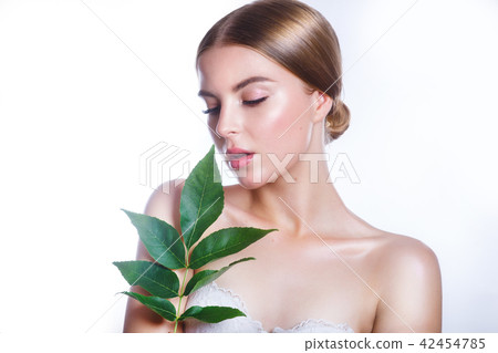 Beautiful woman face portrait with green leaf concept for skin care or organic cosmetics. Studio Beautiful woman face portrait with green leaf concept for skin care or organic cosmetics. Studio 42454785