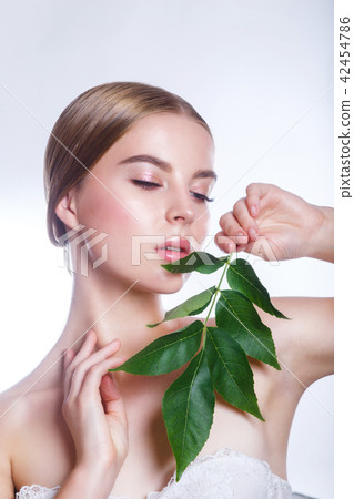 Beautiful woman face portrait with green leaf concept for skin care or organic cosmetics. Studio Beautiful woman face portrait with green leaf concept for skin care or organic cosmetics. Studio 42454786