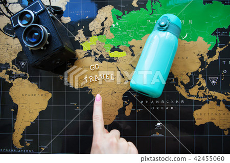 Map of the world in Russian. The finger of the girl points to different corners of the world. 42455060