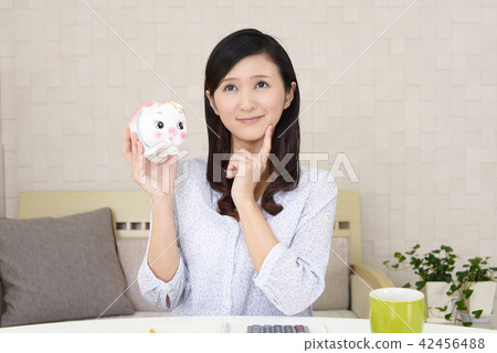 有豬的存錢罐的一名婦女 有豬的存錢罐的一名婦女 42456488