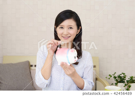 A woman with pig's piggy bank A woman with pig's piggy bank 42456489