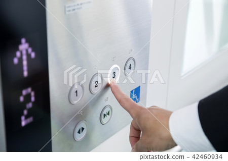 Businessman pushing the button of the elevator 42460934